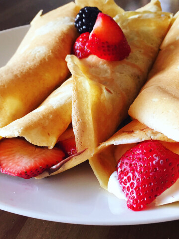 Crepes with berries on a white plate