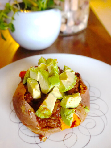 Enchilada stuffed sweet potato on a white plate