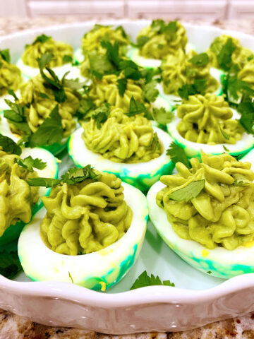 Dragon deviled eggs on a white platter on a counter.