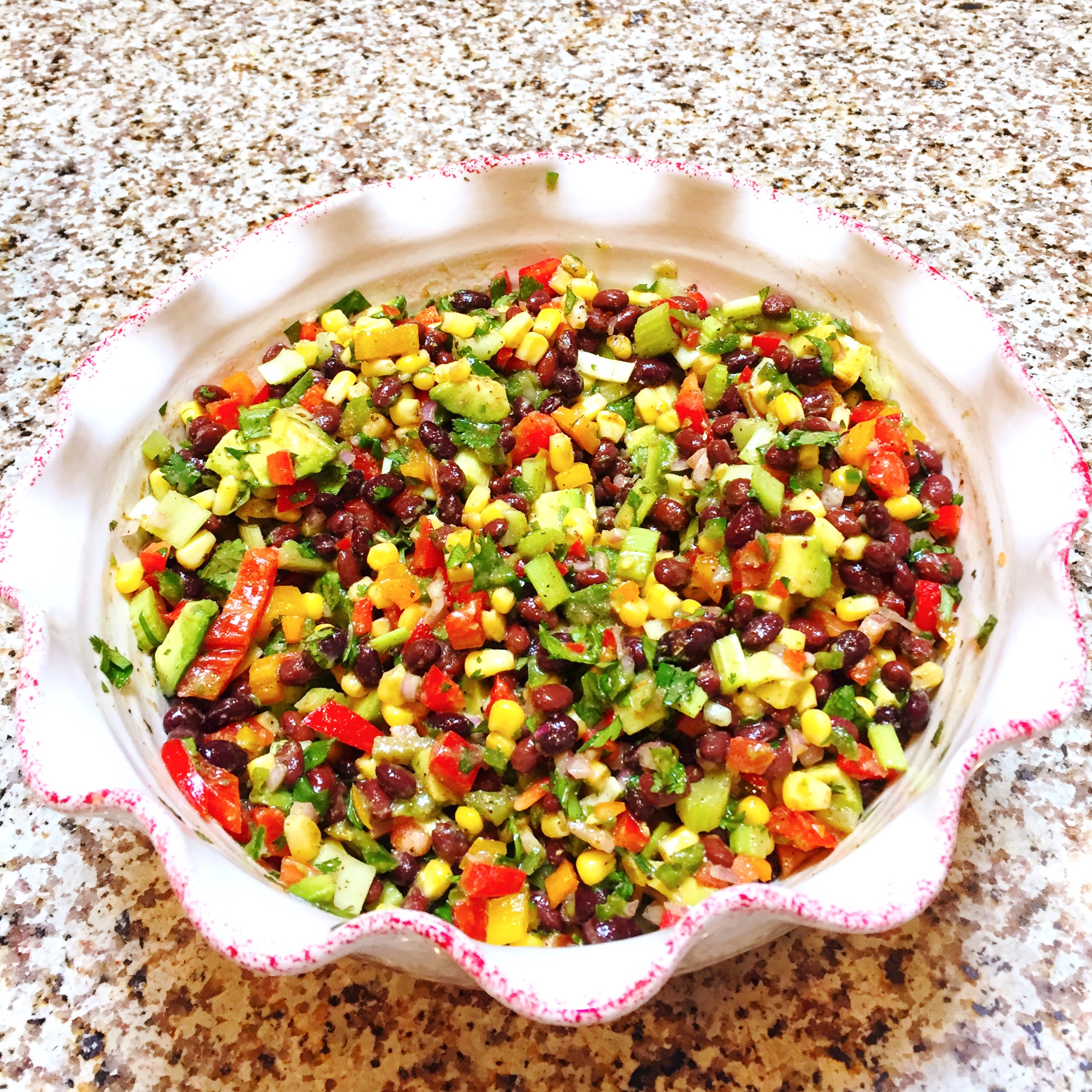 sweet and spicy black bean salad in a bowl on a granite countertop.