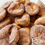 A pile of browned butter cinnamon-sugar popovers on a white background