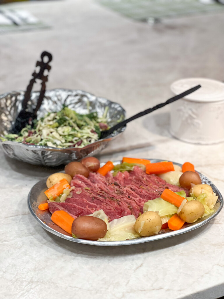 Corned beef and cabbage with salad on a white countertop