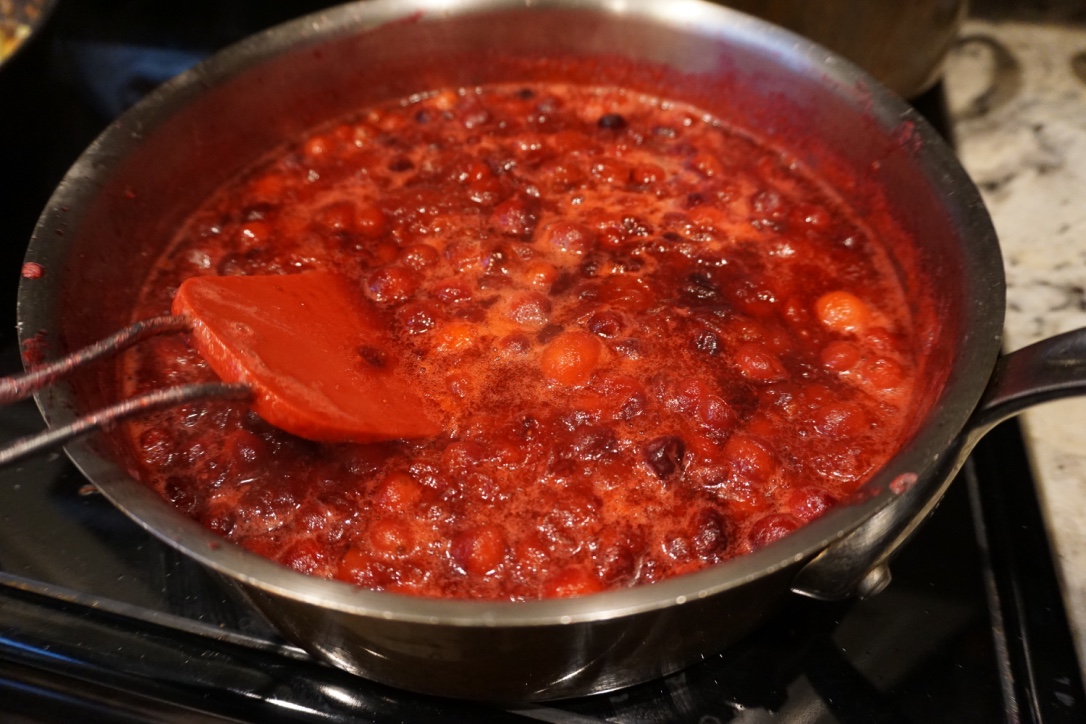 Simmering cranberry sauce in a pan on the stovetop