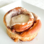 A cinnamon roll on a white plate