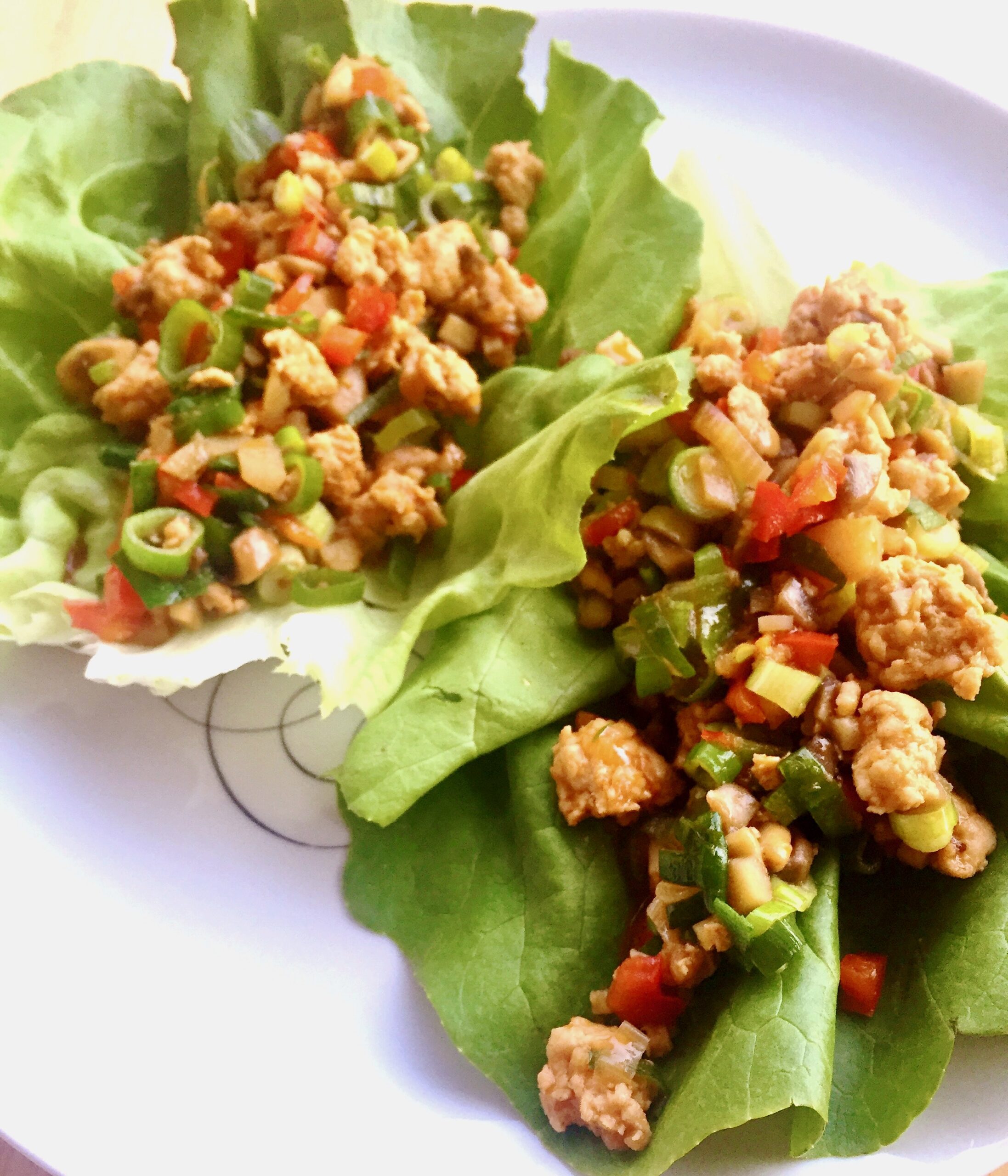 Chicken lettuce wraps on a white plate.